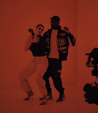 Камера на крані фіксує сцену у світловому кубі з червоним фільтром — постановка кліпу KISS