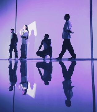 Чотири актори позують на глянцевій підлозі — постановка з фіолетовим світлом у кліпі Dannisha