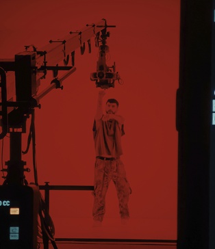 Актор у червоному світлі взаємодіє з роботизованою камерою — сцена з кліпу Dannisha KISS